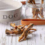 Load image into Gallery viewer, Dog treats on a wooden surface with a 'DOG' bowl and jar in the background.