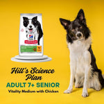 Load image into Gallery viewer, Dog sitting next to a package of Hill's Science Plan dog food on a yellow background
