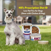 Dog sitting on grass with Hill's Prescription Diet ID pet food containers.