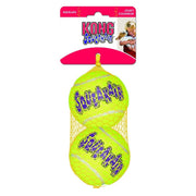 Two yellow tennis balls with 'Kong Squeakair' branding on a pink packaging background.