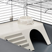 Pet cage with a white platform, steps, and a bowl.