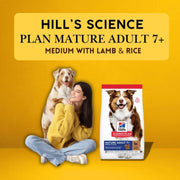 Woman holding a dog with a Hills Science Plan dog food package on a yellow background