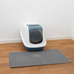 Load image into Gallery viewer, Cat litter box with a mat on a wooden floor against a white wall
