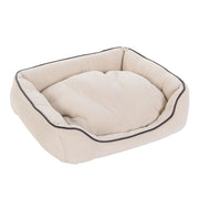 Beige pet bed with dark piping on a white background